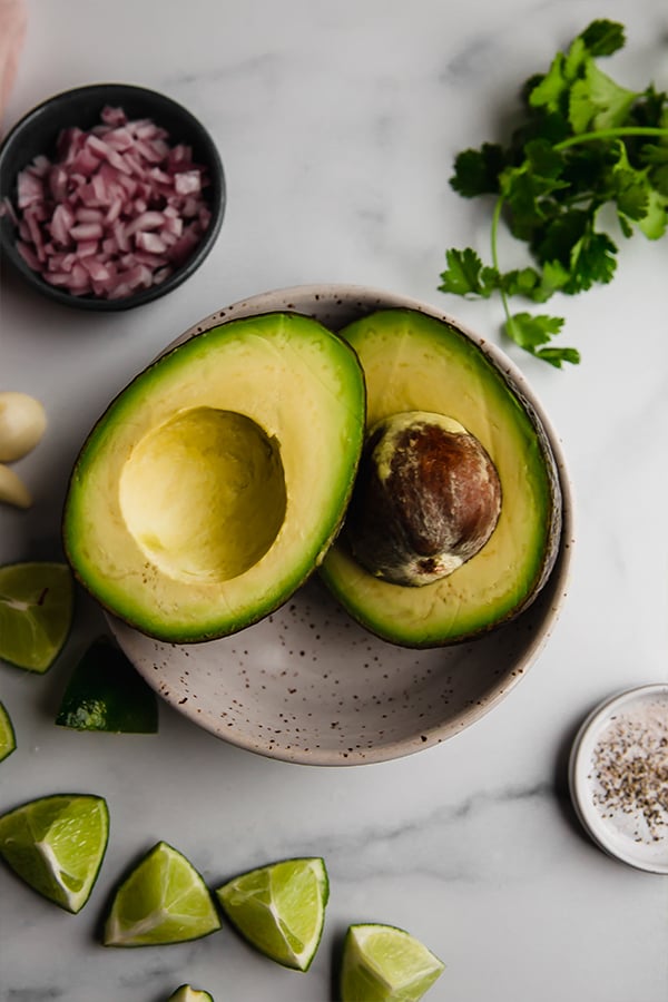 Avocado cut in half in bowl