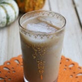 Iced pumpkin spice latte in a white and gold glass