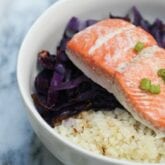 A bowl with cabbage, cauliflower rice, and salmon in it.