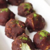 A row of chocolate matcha energy balls sitting on a platter.