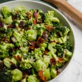 A white bowl filled with avocado bacon broccoli salad.