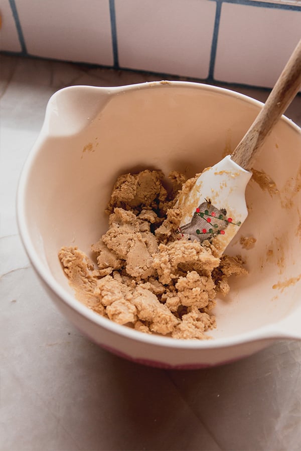 A bowl of gingerbread donut holes dough being mixed.