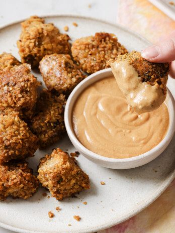 Chicken nuggets dipped in sauce.