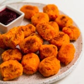 Plate of sweet potato tater tots with a bowl of dip.