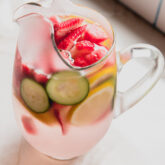 Ginger infused water and fruit in a glass pitcher.