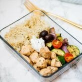 Greek chicken meal in a glass container.