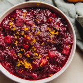 Apple cranberry sauce in a bowl topped with orange zest.