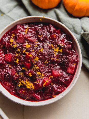 Apple cranberry sauce in a bowl topped with orange zest.