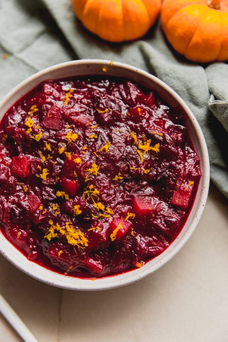 Apple cranberry sauce in a bowl topped with orange zest.