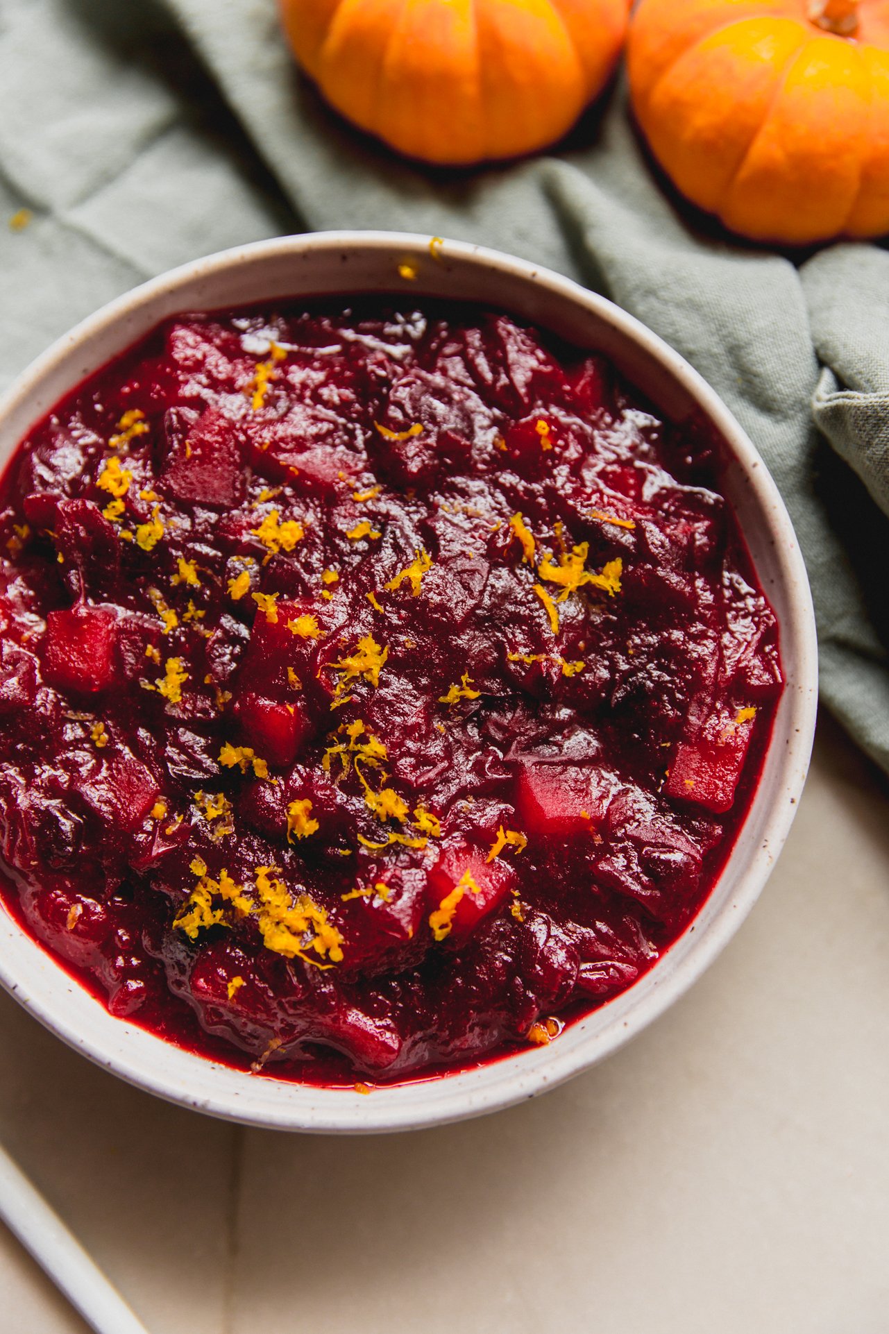 Apple cranberry sauce in a bowl topped with orange zest.