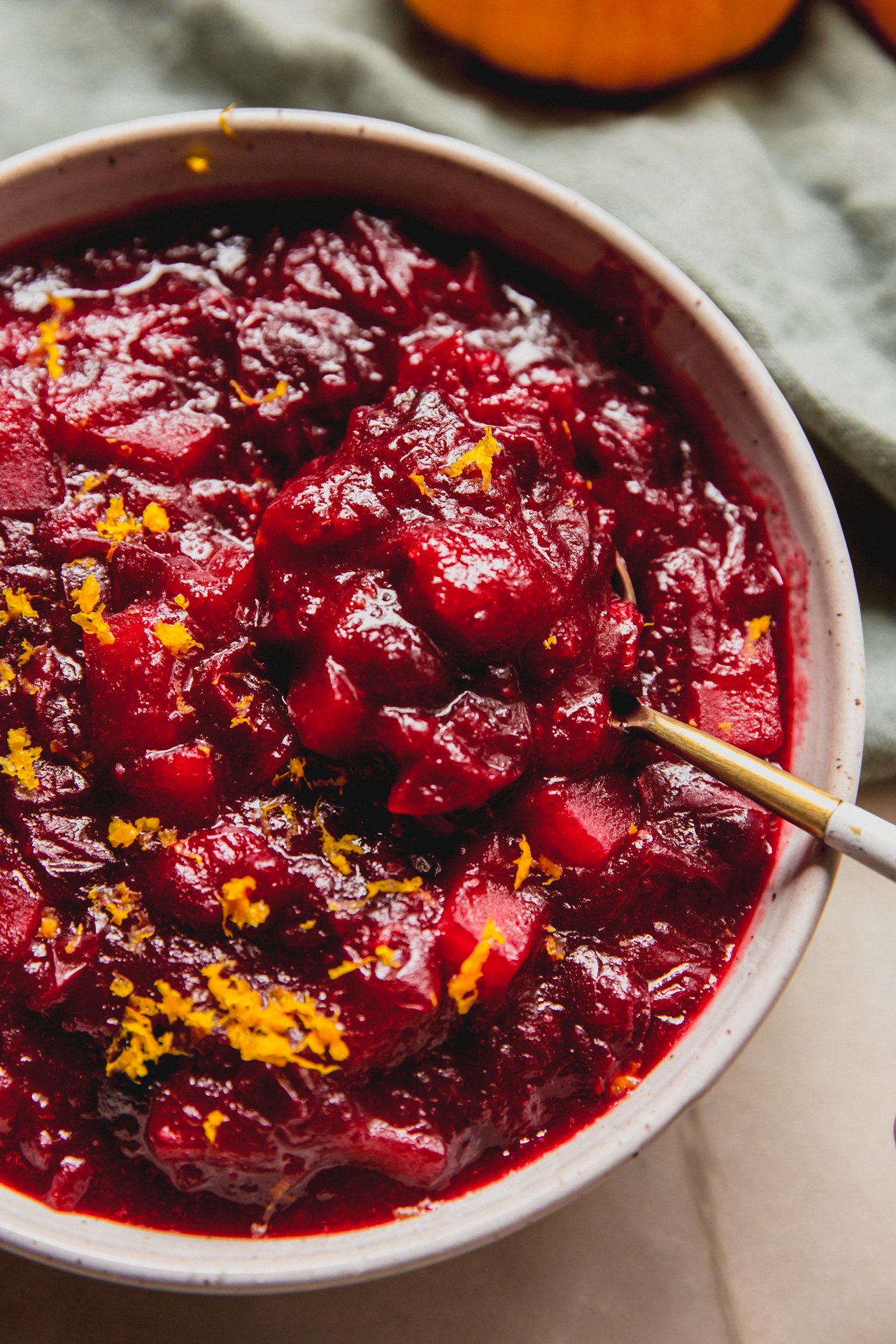 Apple cranberry sauce in a bowl with a spoon.
