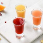 Three apple cider vinegar shots on a platter.
