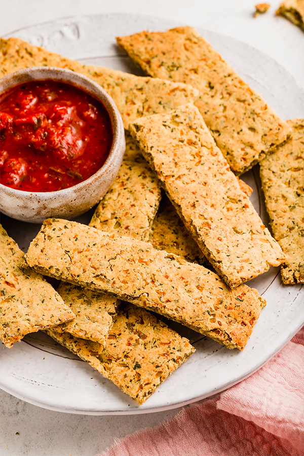 A plate of cauliflower breadsticks with dipping sauce.