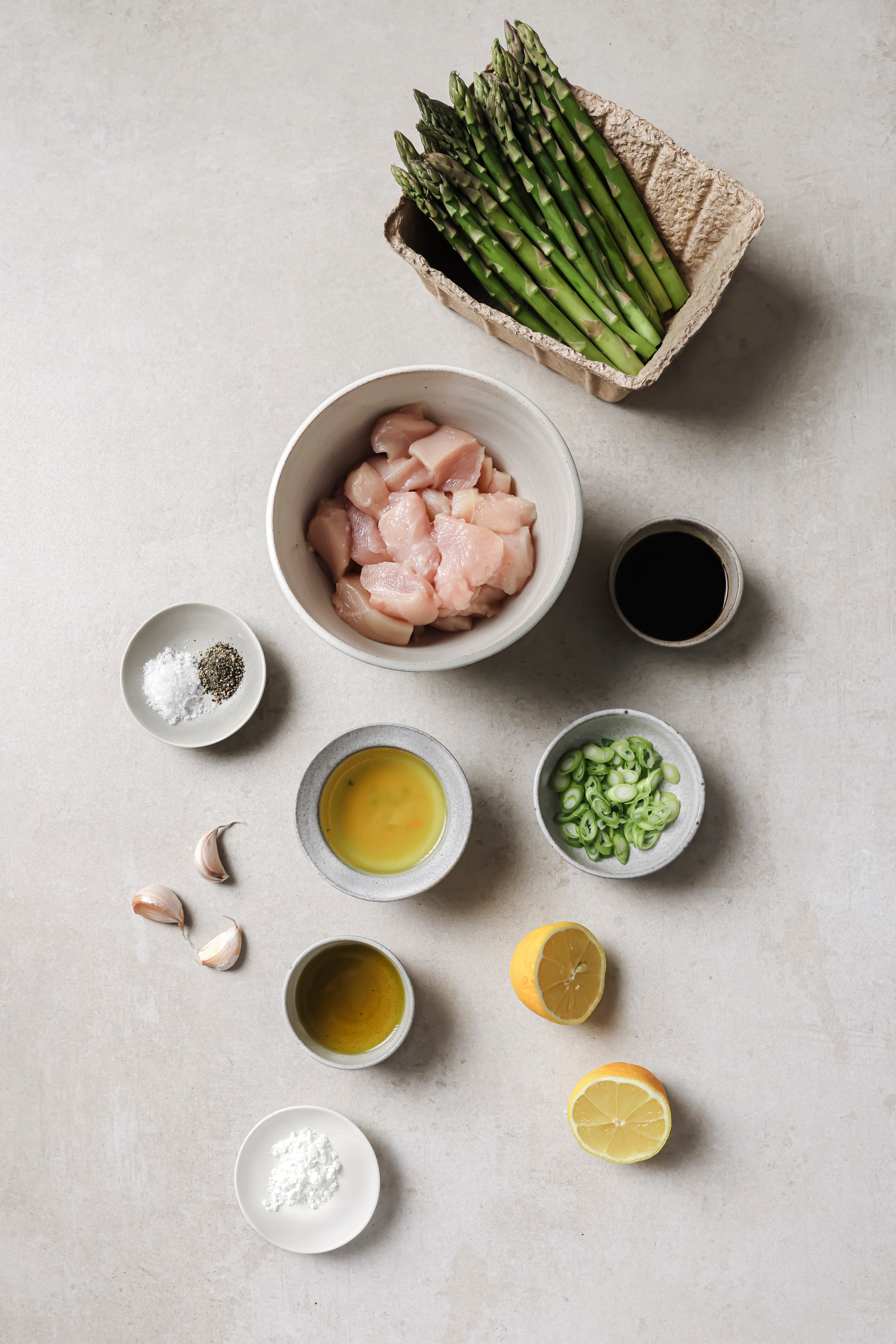 All the ingredients needed for lemon & asparagus chicken skillet laid out on a counter.