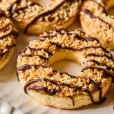 Samoa cookies with chocolate drizzle on a white platter