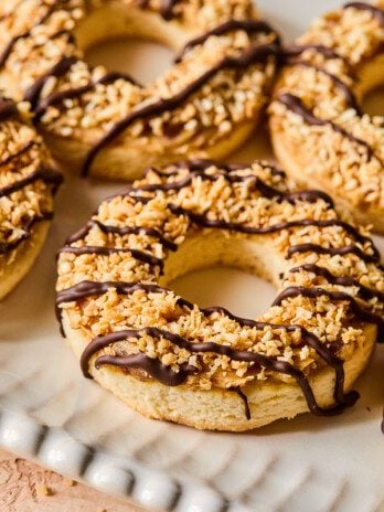 Samoa cookies with chocolate drizzle on a white platter