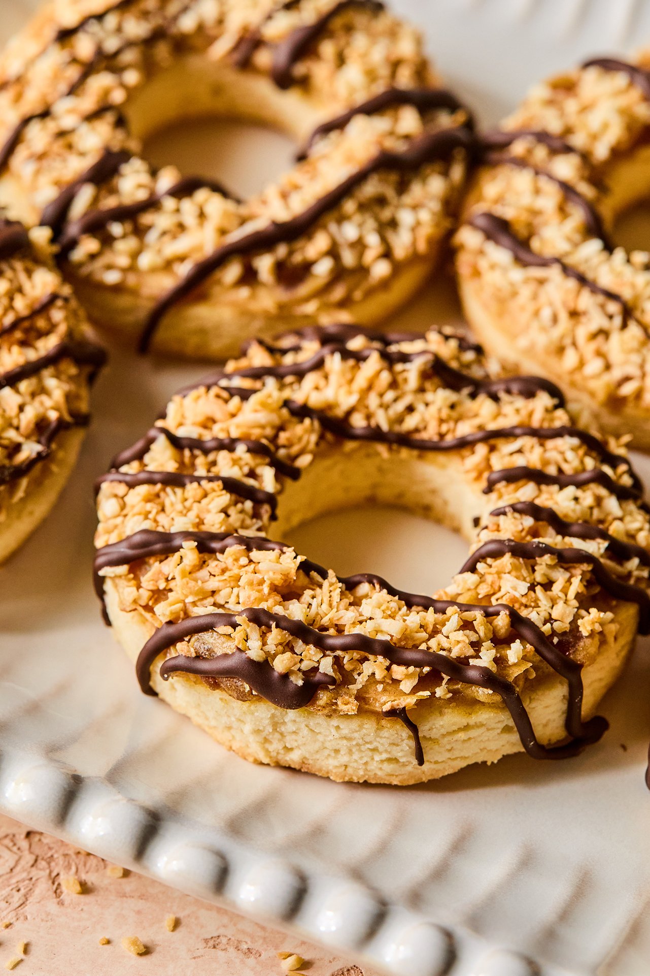 Samoa cookies with chocolate drizzle on a white platter
