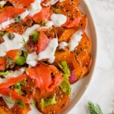 A white plate filled with everything bagel & lox breakfast nachos.