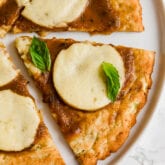 A white plate with zucchini pizza crust slices on it.