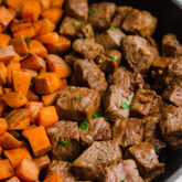 A pan filled with cut up sweet potato and steak to make one pan steak bites & sweet potato.