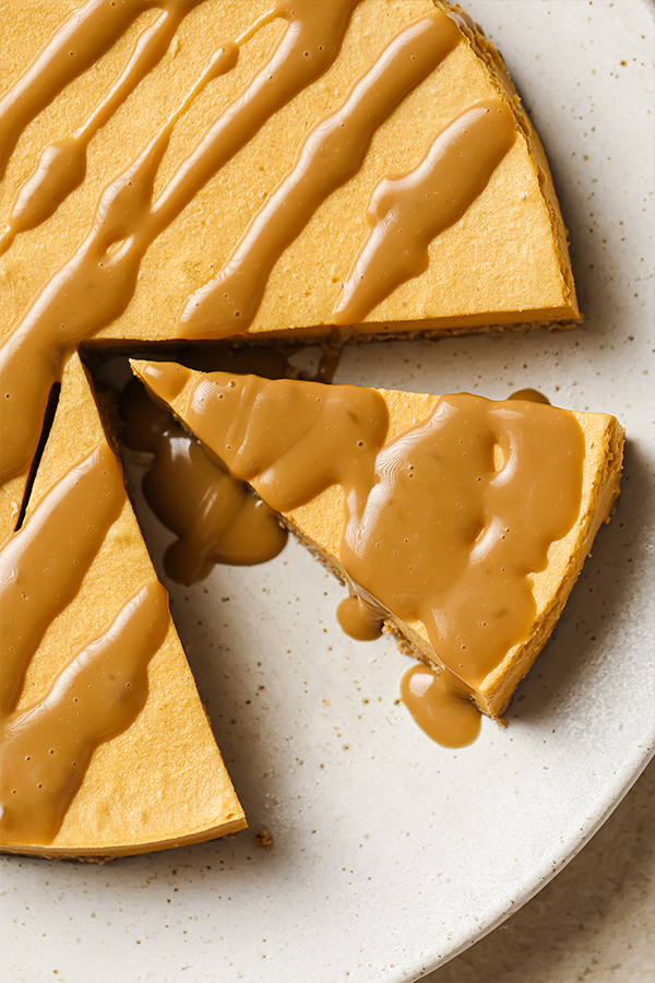Slices of cheesecake on a plate topped with caramel.