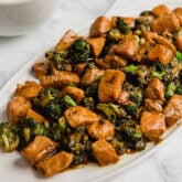 A serving platter filled with chicken and broccoli stir fry ready to be eaten.