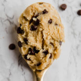 A large spoon with edible cookie dough on it.