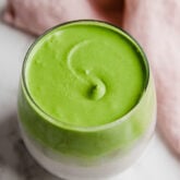 A glass filled with dalgona matcha.