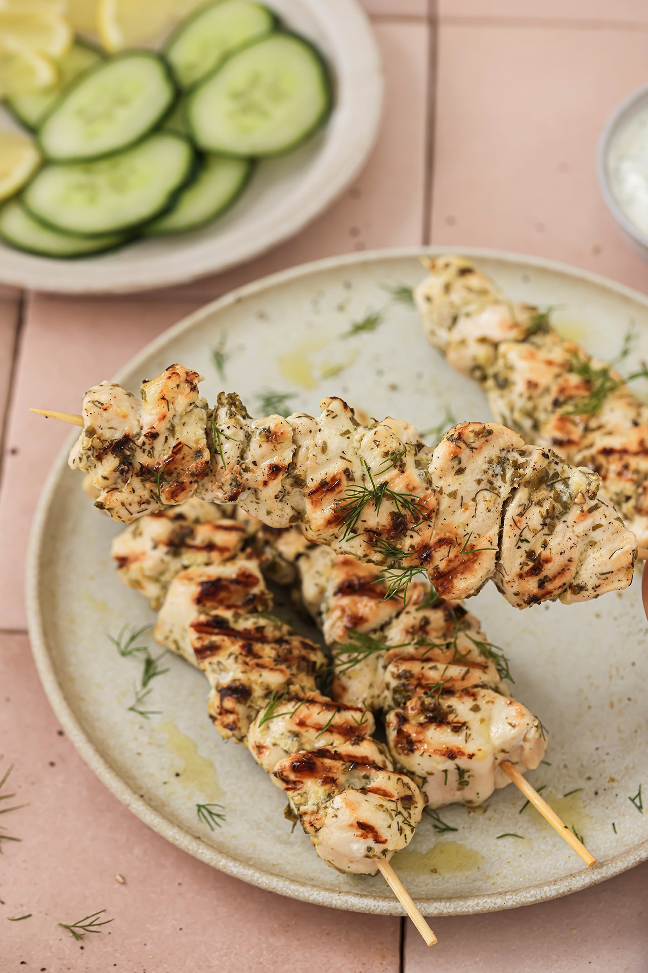 Chicken souvlaki with one skewer being picked up.