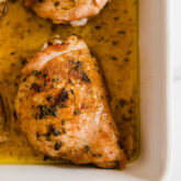 A white baking sheet with balsamic ranch chicken thighs after baking.