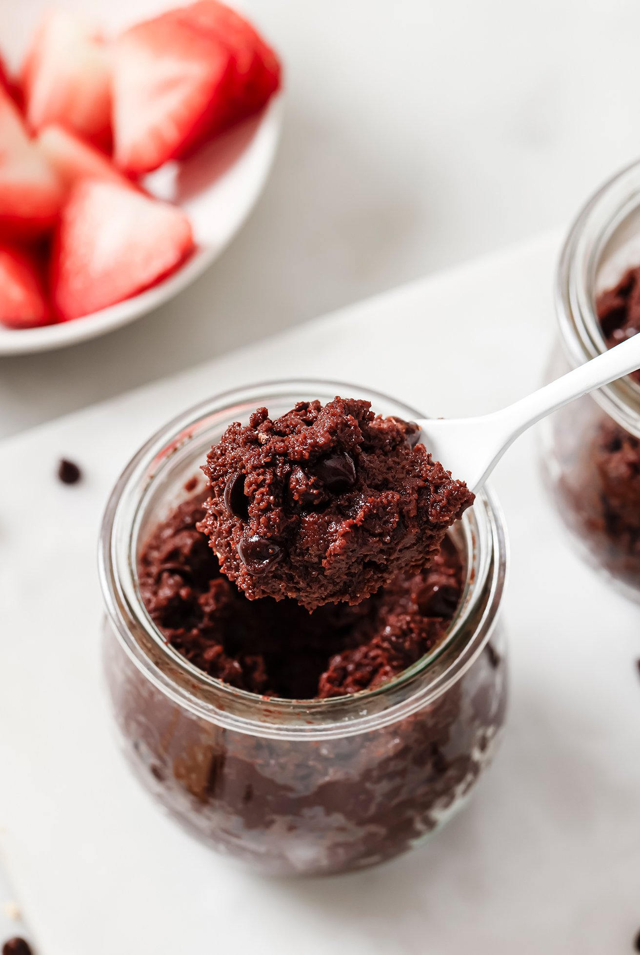 Gluten free brownie batter in a jar with a spoon.