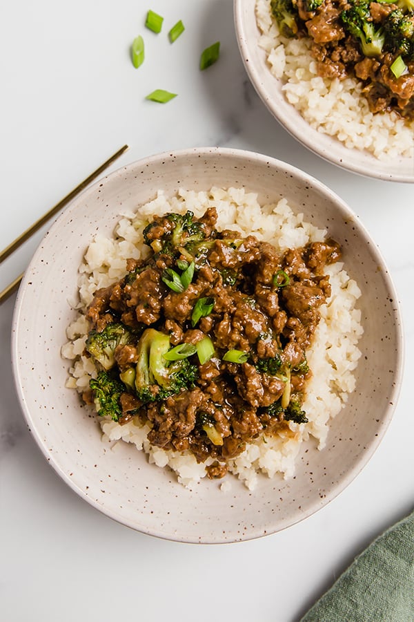 Ground beef and broccoli in two bowls with chopsticks