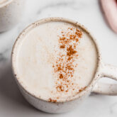 A white ceramic mug filled with a snickerdoodle latte.