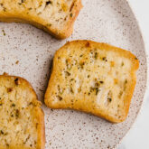 A speckled plate with three slices of gluten free texas toast.