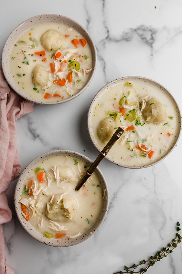chicken and cauliflower dumplings in 3 bowls with spoon