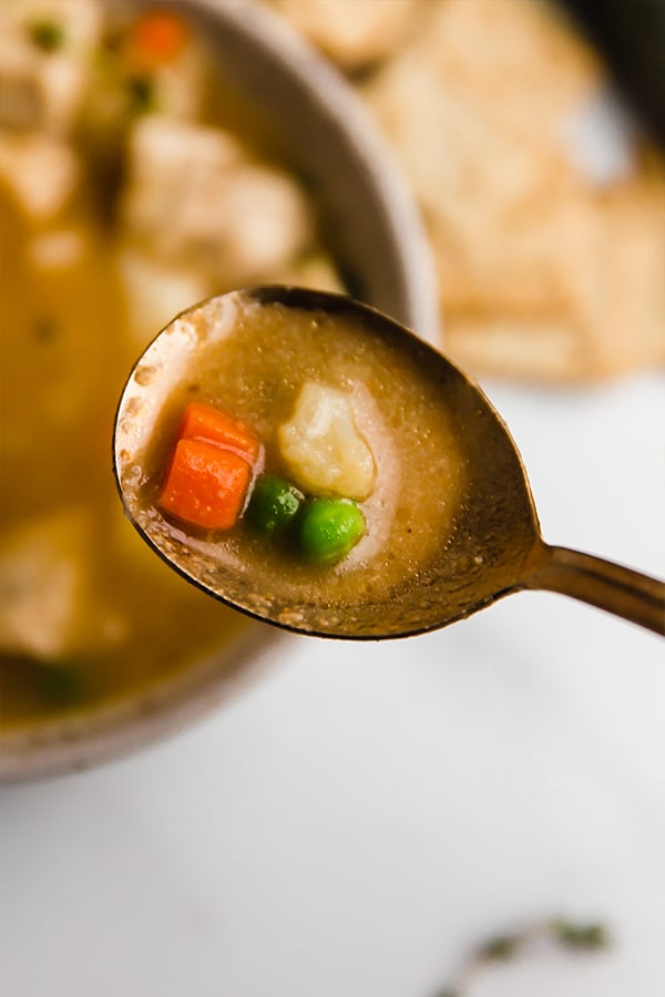 chicken pot pie soup in bowl with soup in spoon