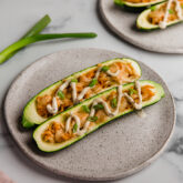 Buffalo chicken stuffed zucchini boats on a plate.