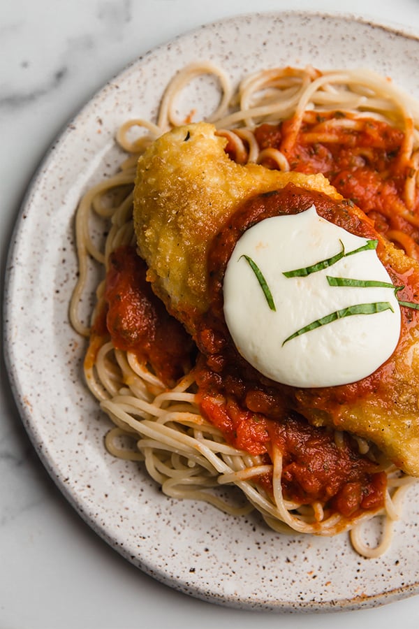 chicken parmesan on a plate with spaghetti