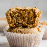 Stack of lemon zucchini poppyseed muffins missing a bite.