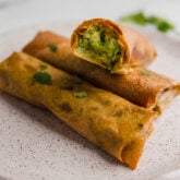 Avocado egg rolls on a plate.