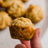 Person holding a gluten-free veggie muffin.