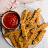 Zucchini fries on a plate with dip.