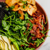Breakfast salad with avocado and bacon in a bowl.