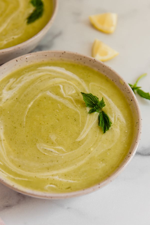 Basil zucchini soup served in a bowl topped with basil