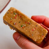 Person holding cake batter protein bar.