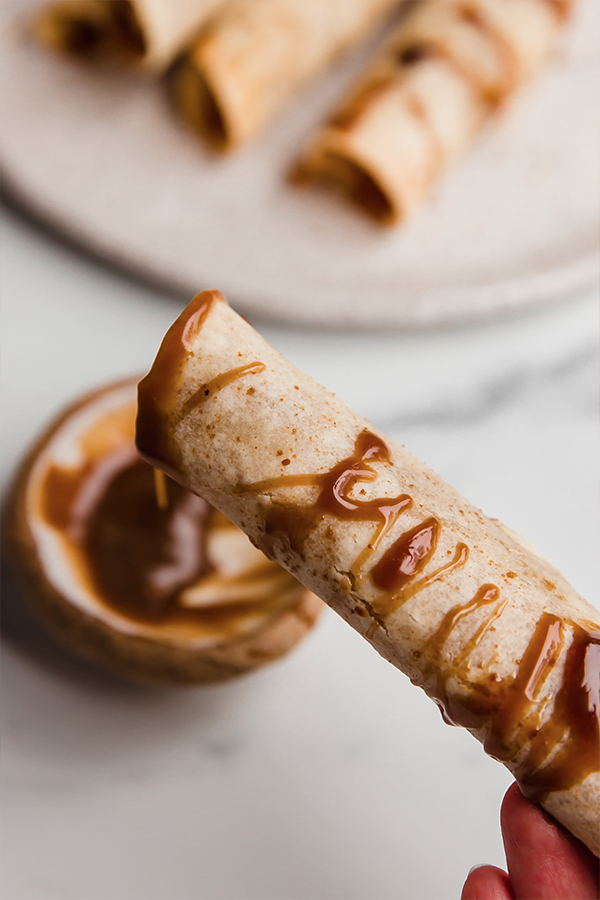 A apple pie roll-up with caramel sauce. 