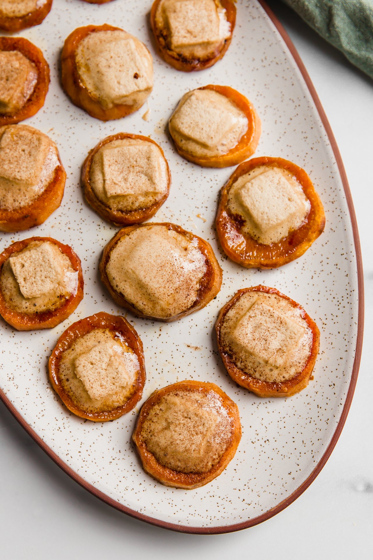 Sweet potato casserole bites with melted marshmallows on a large platter.