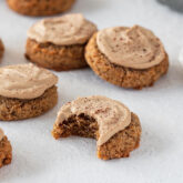 Several tiramisu cookies, one of which is missing a bite.