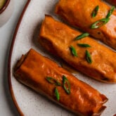 Buffalo chicken egg rolls on a plate.