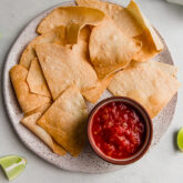 Almond flour tortilla chips on a plate with sauce.